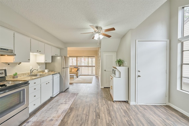 kitchen with sink, white appliances, light hardwood / wood-style flooring, plenty of natural light, and white cabinets