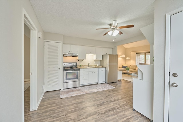 kitchen featuring hardwood / wood-style flooring, white cabinetry, appliances with stainless steel finishes, and sink