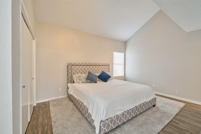 bedroom featuring wood-type flooring, vaulted ceiling, and a textured ceiling