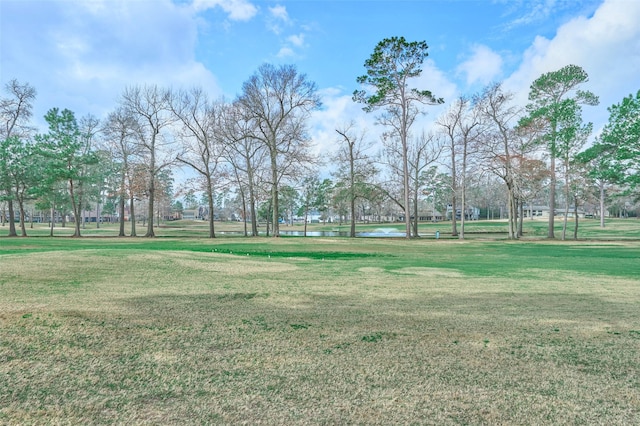 view of property's community featuring a lawn and a water view