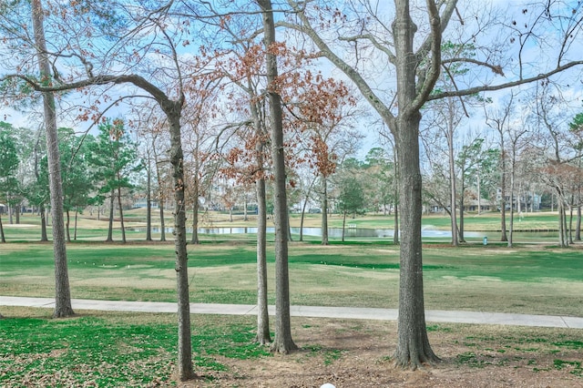 surrounding community with a water view and a yard