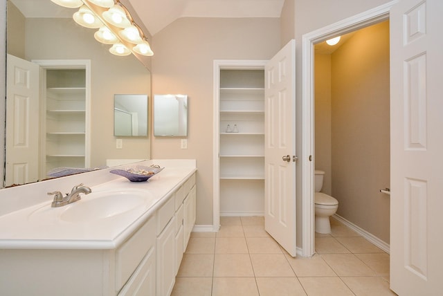 bathroom featuring lofted ceiling, tile patterned floors, toilet, and vanity