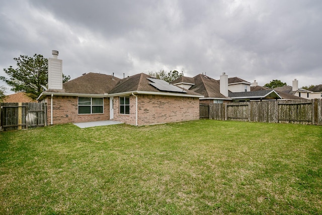 rear view of property featuring a lawn and a patio