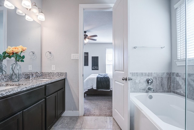 bathroom featuring ceiling fan, plenty of natural light, vanity, and a washtub