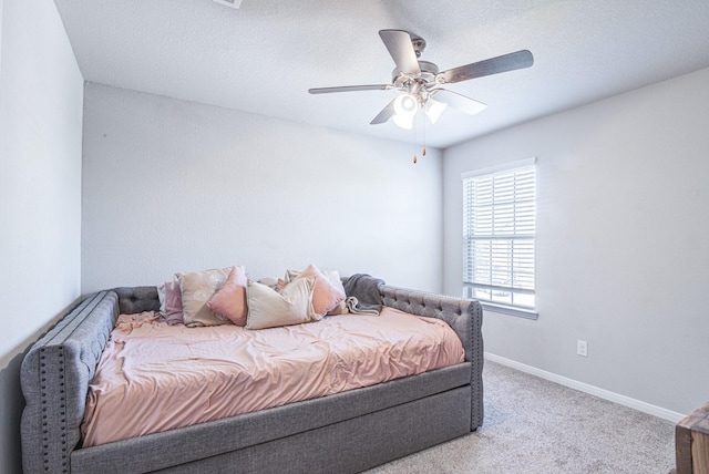 bedroom with a textured ceiling, light colored carpet, and ceiling fan