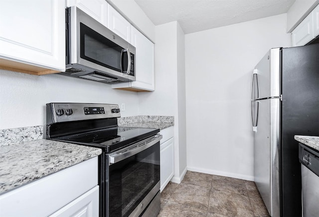 kitchen featuring appliances with stainless steel finishes, a textured ceiling, white cabinets, and light stone counters