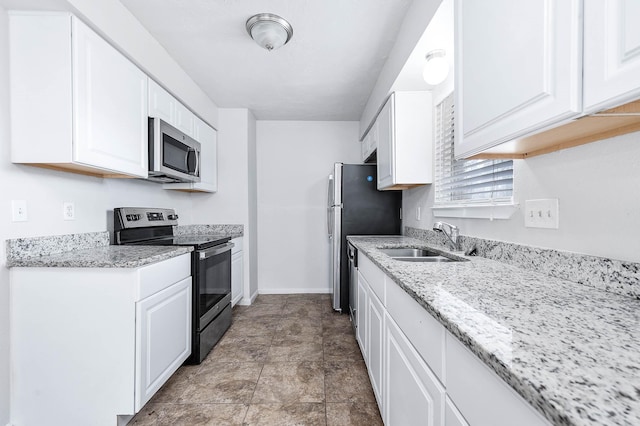 kitchen featuring white cabinetry, sink, light stone counters, and stainless steel appliances