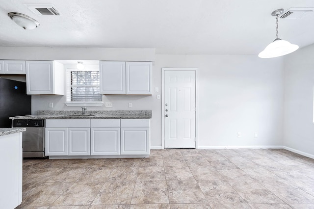 kitchen featuring sink, white cabinetry, black fridge, hanging light fixtures, and dishwasher