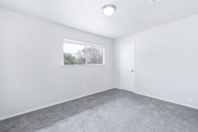 empty room featuring dark colored carpet and a textured ceiling