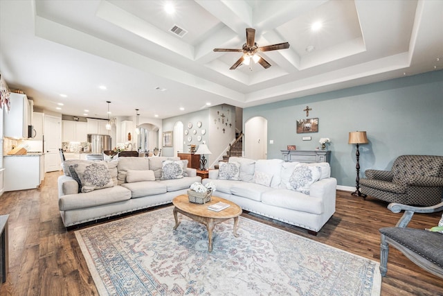 living room with beamed ceiling, ceiling fan, coffered ceiling, and dark hardwood / wood-style flooring