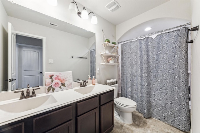 bathroom featuring toilet, double vanity, a sink, and visible vents