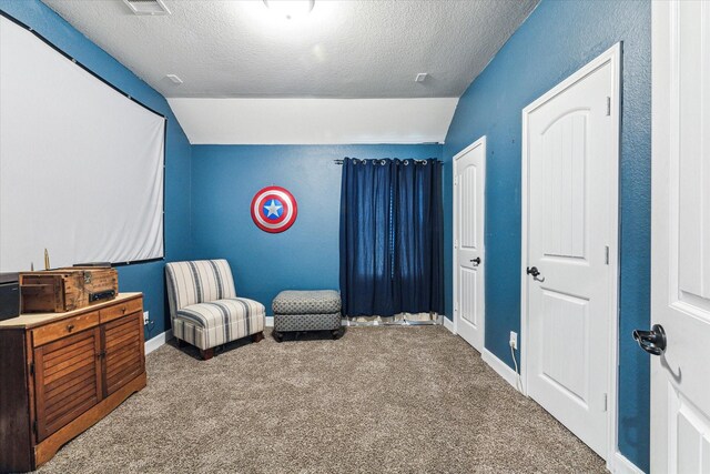 living area featuring lofted ceiling, carpet floors, and a textured ceiling