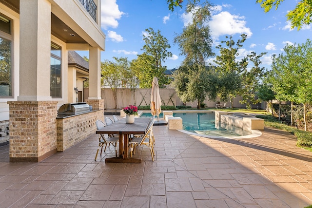 view of patio / terrace featuring area for grilling, a balcony, and a pool with hot tub