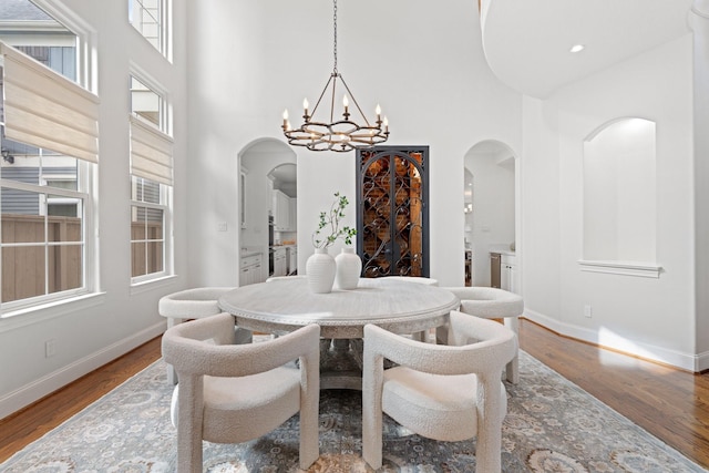 dining room featuring a high ceiling, hardwood / wood-style floors, and a notable chandelier