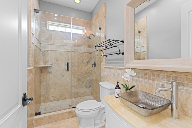 bathroom featuring toilet, a shower with shower door, sink, tile walls, and backsplash