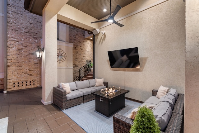 view of patio / terrace featuring ceiling fan and an outdoor living space with a fire pit