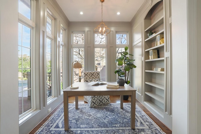 office area with crown molding, dark hardwood / wood-style flooring, a chandelier, and built in features