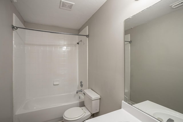 full bathroom featuring tiled shower / bath, vanity, and toilet