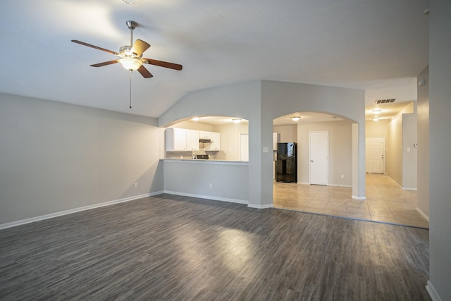 unfurnished living room featuring ceiling fan, lofted ceiling, and light hardwood / wood-style floors