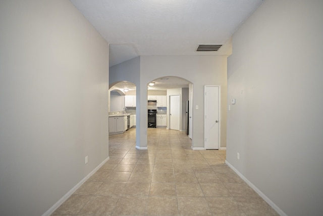 hallway with light tile patterned floors and sink