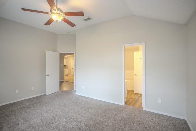 unfurnished bedroom featuring lofted ceiling, light colored carpet, ceiling fan, and ensuite bathroom