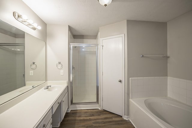 bathroom with vanity, wood-type flooring, independent shower and bath, and a textured ceiling