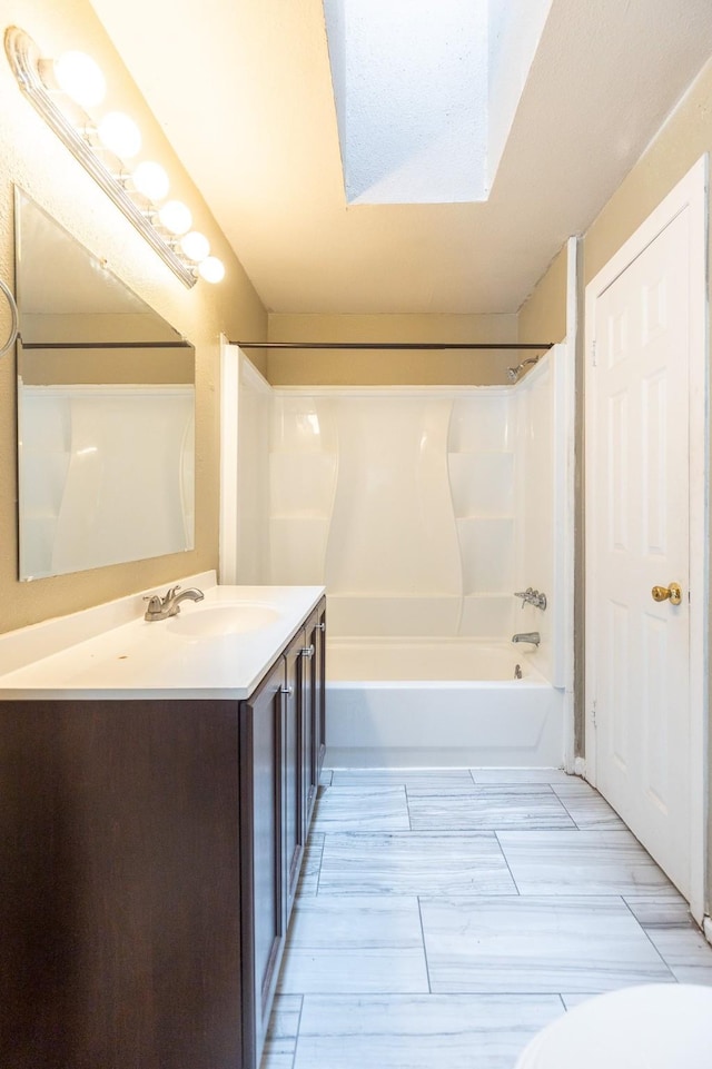 bathroom featuring vanity, bathtub / shower combination, and a skylight