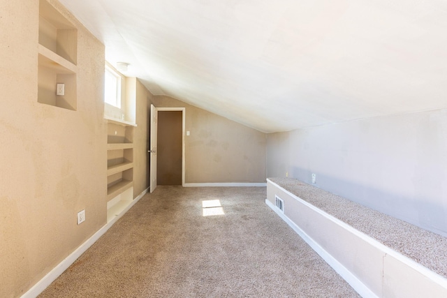 additional living space with lofted ceiling, carpet, and built in features