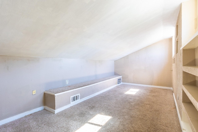 bonus room featuring vaulted ceiling and carpet flooring