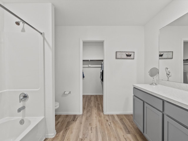 full bathroom featuring vanity, hardwood / wood-style flooring, shower with separate bathtub, and toilet