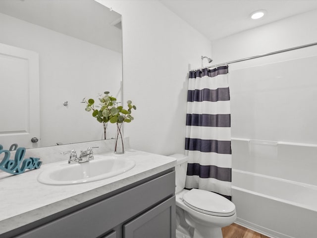 full bathroom featuring hardwood / wood-style flooring, vanity, shower / tub combo with curtain, and toilet