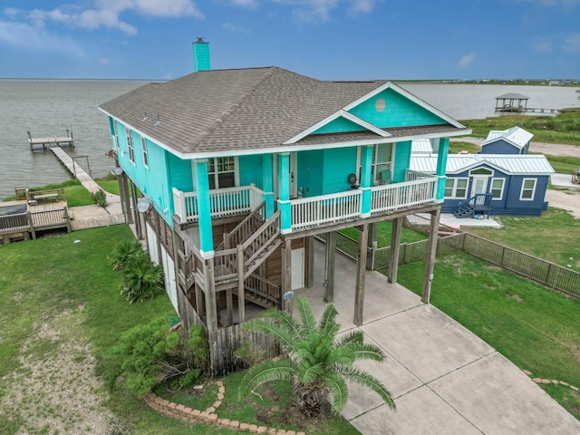 exterior space with a yard, a carport, a porch, and a water view