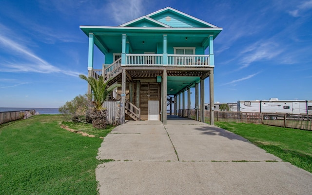 beach home with a porch, a carport, and a front lawn