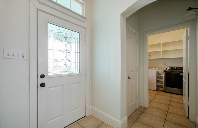 entrance foyer featuring separate washer and dryer, plenty of natural light, and light tile patterned floors