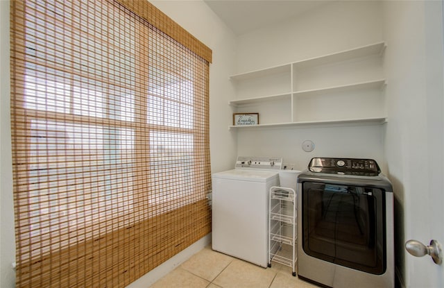 clothes washing area featuring washing machine and clothes dryer and light tile patterned floors