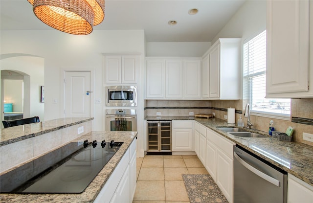 kitchen with sink, tasteful backsplash, stainless steel appliances, beverage cooler, and white cabinets