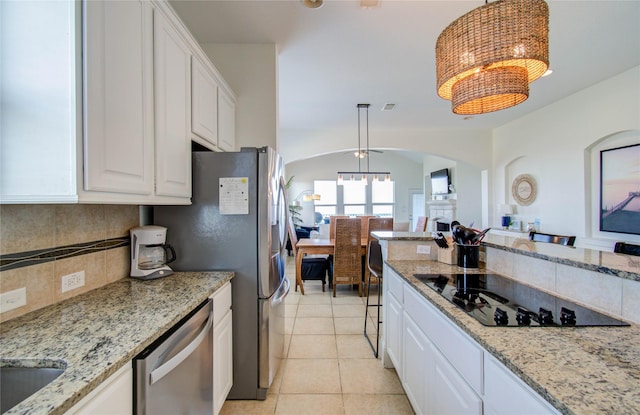 kitchen with white cabinetry, appliances with stainless steel finishes, decorative light fixtures, and an inviting chandelier