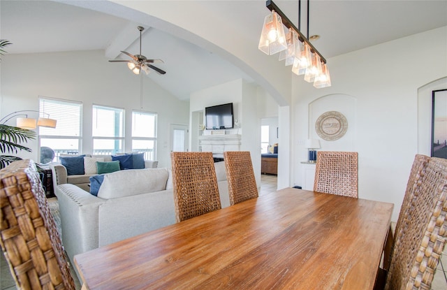 dining space with ceiling fan, high vaulted ceiling, and beam ceiling