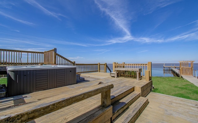 wooden terrace featuring a water view and a hot tub