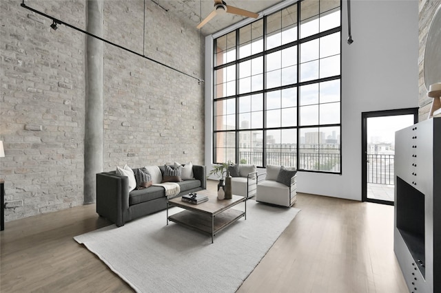 living room with a high ceiling, wood-type flooring, and plenty of natural light