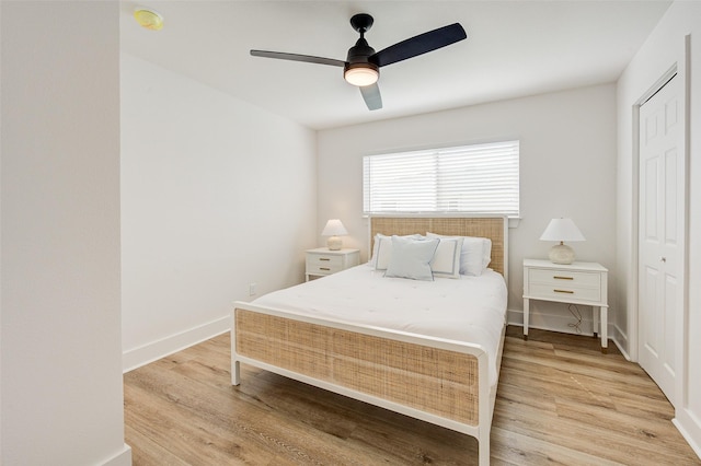 bedroom with light hardwood / wood-style flooring, a closet, and ceiling fan