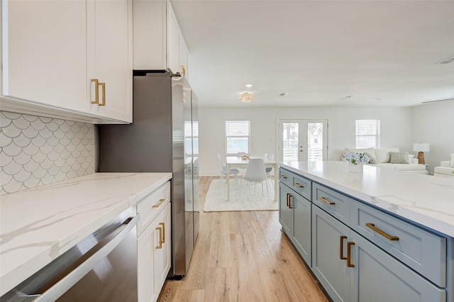 kitchen featuring light stone countertops and white cabinets