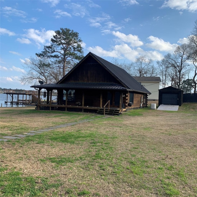 back of house with a water view, a garage, central AC, and a lawn