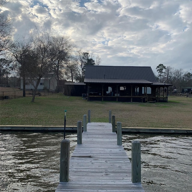 view of dock featuring a water view and a lawn