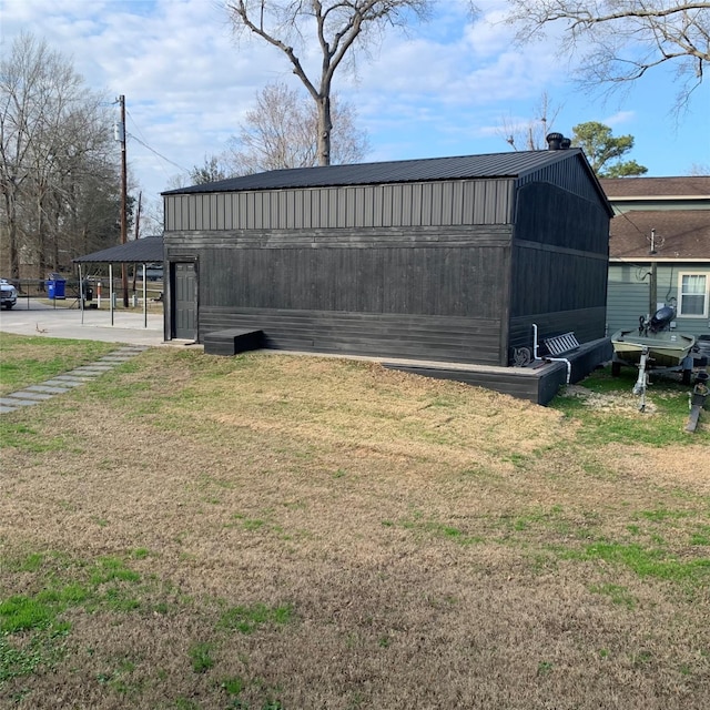 view of outbuilding featuring a carport and a lawn