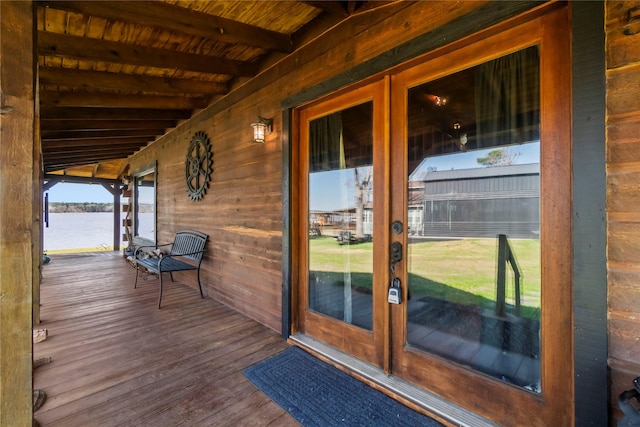 wooden deck featuring a water view and french doors