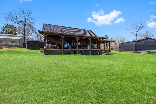 rear view of property featuring a yard and an outdoor structure