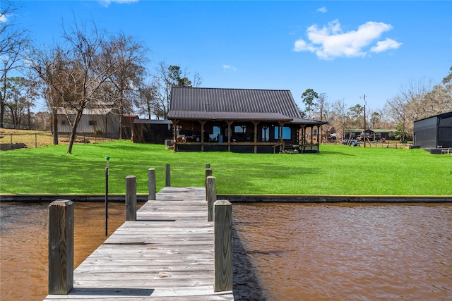 view of dock with a yard and a water view