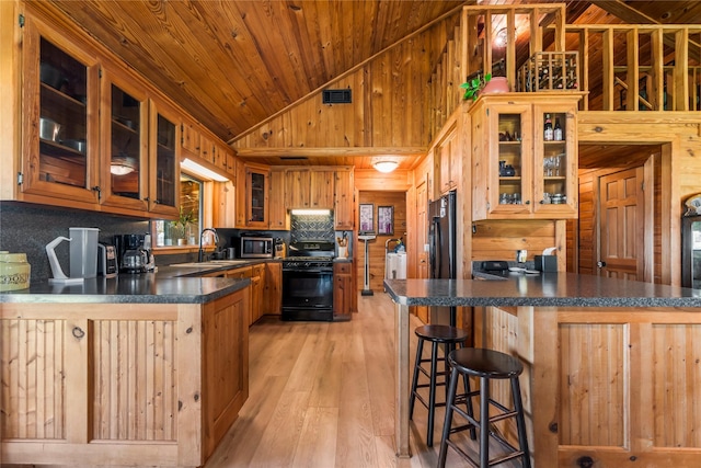 kitchen featuring light wood-type flooring, kitchen peninsula, black appliances, sink, and wooden ceiling