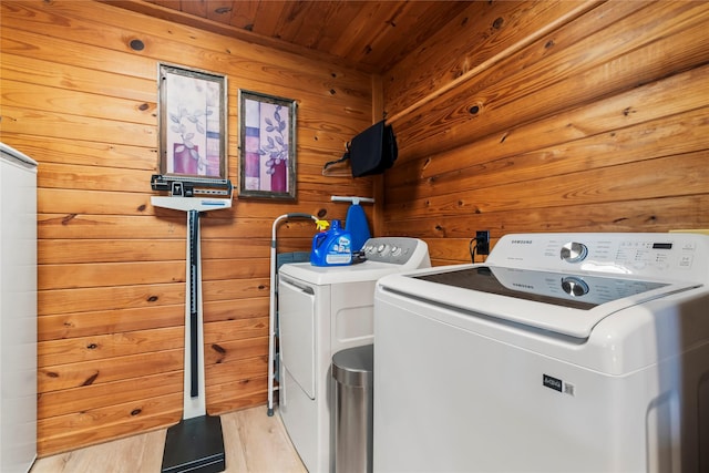 washroom featuring light hardwood / wood-style floors, washer and dryer, wooden ceiling, and wood walls